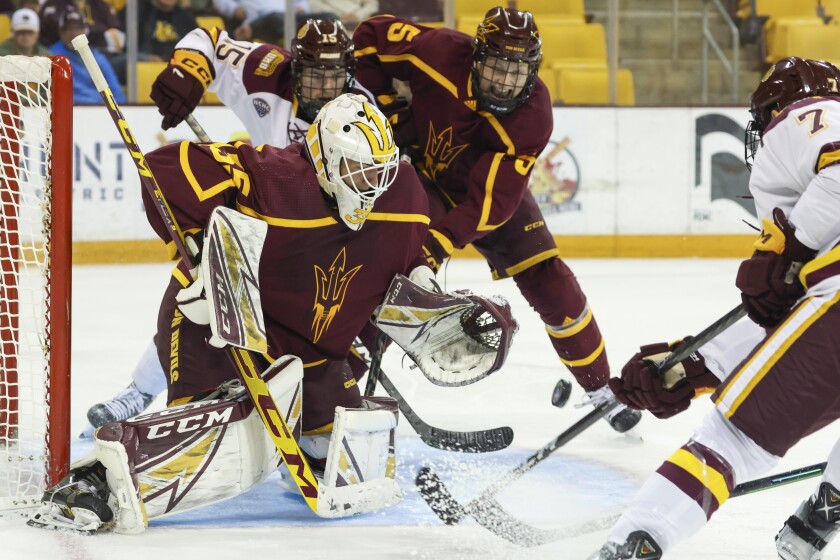 College hockey players play game in indoor arena