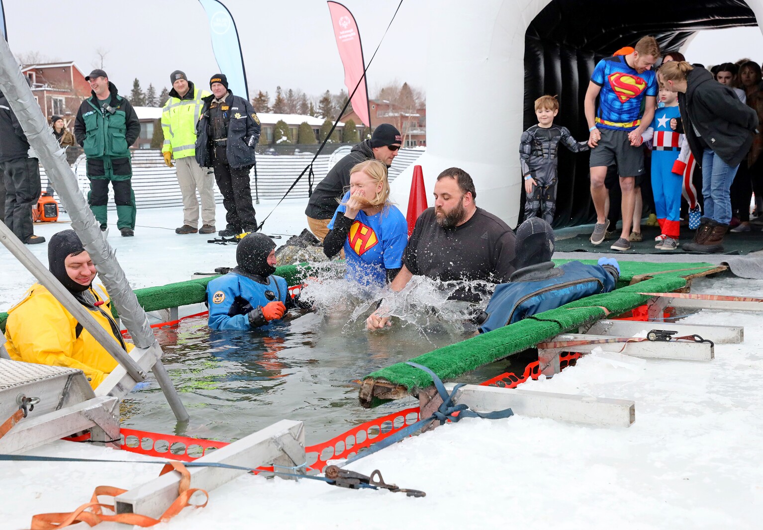 People jump into the water during the Polar Plunge event on Pelican Lake.