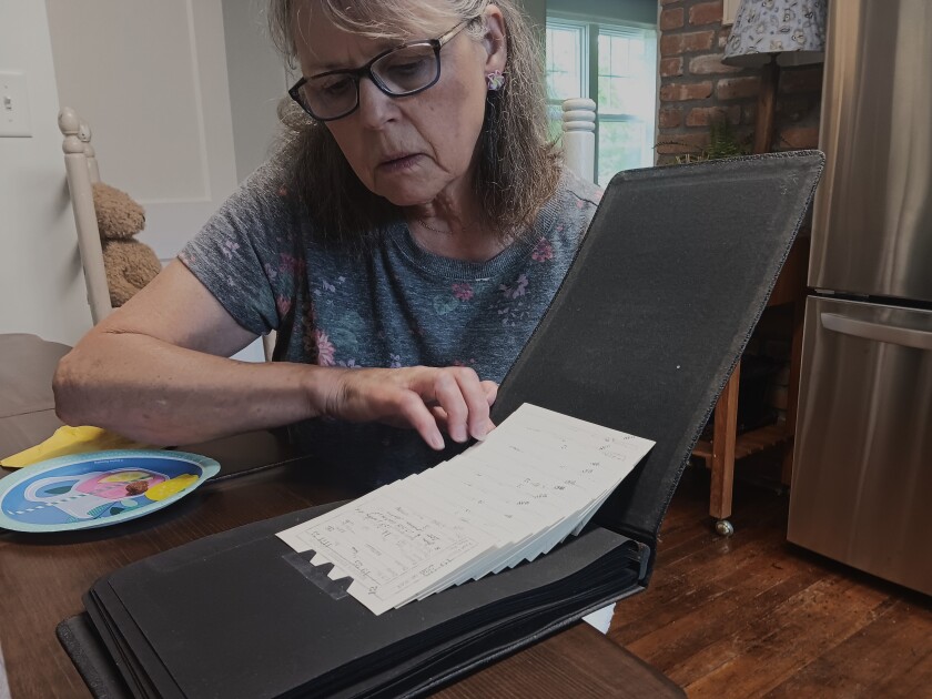Susan Knudsen se dívá na jedno z fotoalb, které objevila v pondělí 21. července 2025 patřící svému dědečku Henry Sorenson.