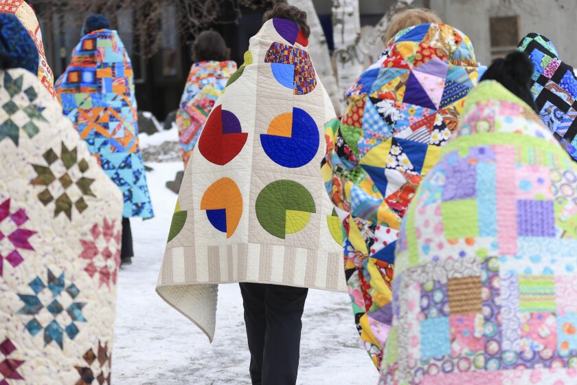 wrapped in quilts people walk through Canal Park in Duluth