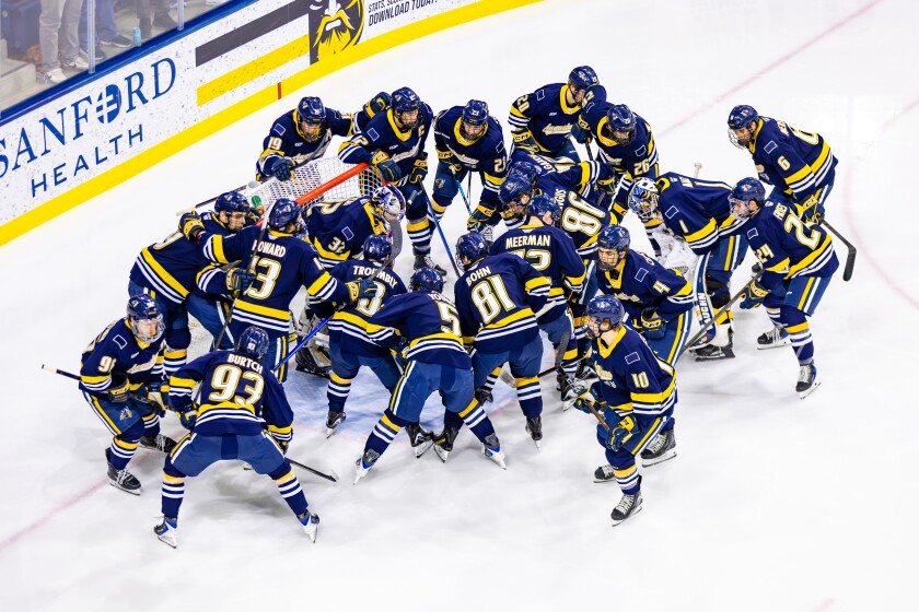 Augustana players huddle around goalie Josh Kotai prior to the start of a game against Ferris State on Friday, Jan. 16, 2026, at Midco Arena in Sioux Falls.