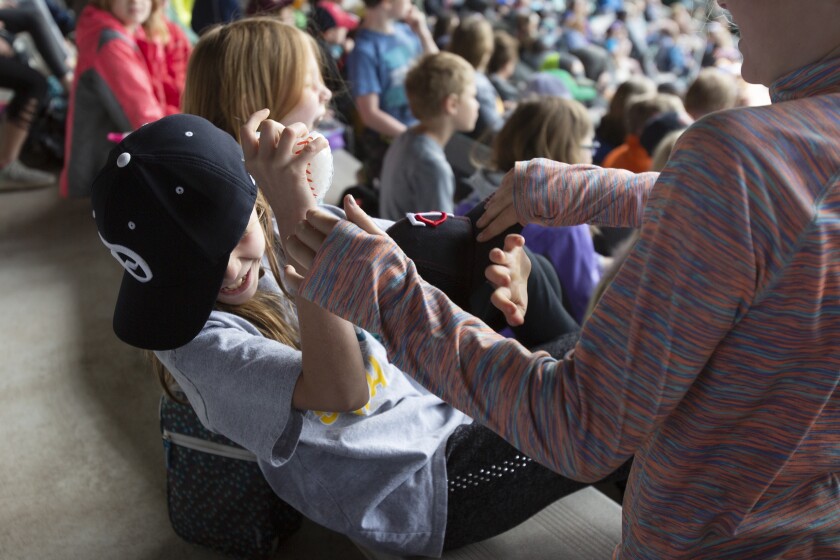 Hermantown Elementary 3rd grader Aubrey Lindahl ducks as her friends try to steal her hat on Monday at Wade Stadium. Lindahl, who attended the Huskies game for the team's annual Education Day, said she likes to go to games with her dad too. Ellen Schmidt / eschmidt@duluthnews.com