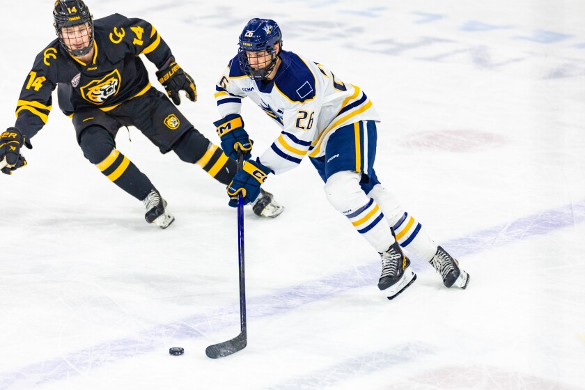 Augustana's Callum Gau skates with the puck while being pressured by Connor Hvidston on Friday, Jan. 2, 2026, at Midco Arena in Sioux Falls.