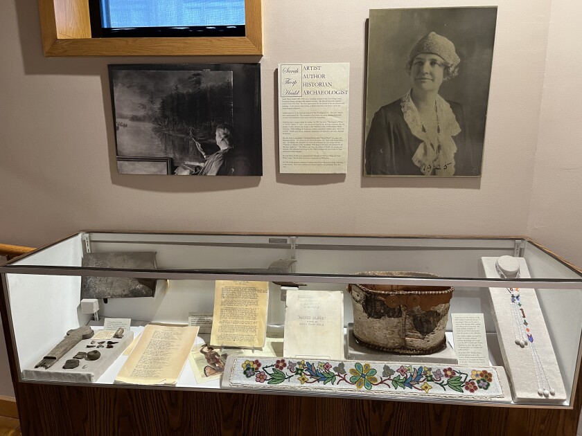 Sarah (Thorp) Heald's portrait is hung above a display of her written works and donations to the Crow Wing County Historical Society of personal artifacts from her archeology collection.