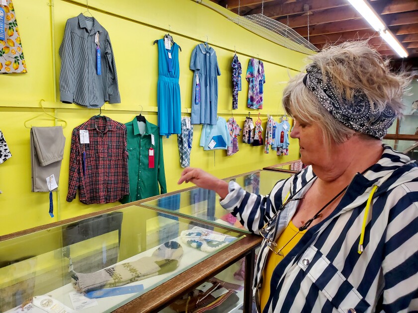 Woman points to a pair of wool socks in a display case