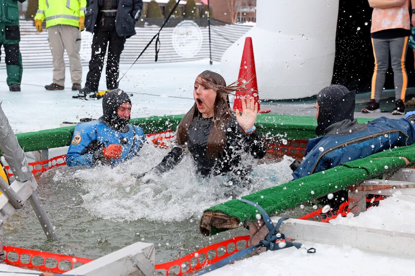 People jump into the water during the Polar Plunge event on Pelican Lake.