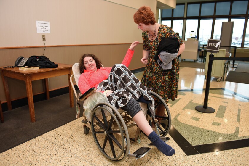Brainerd Dispatch/Steve Kohls Victim of a January 2015 crash on Crow Wing County Highway 3, Macy Kujava (left) motions to her mom, Sue Vanek, in the lobby of the Crow Wing County Judicial Center Thursday. Kujava was transported to the hearing from Bethany Good Samaritan Center for a probation hearing for Vaughn Gentry, who was responsible for the crash. Video and Gallery