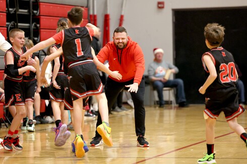Coach greets his players on court.