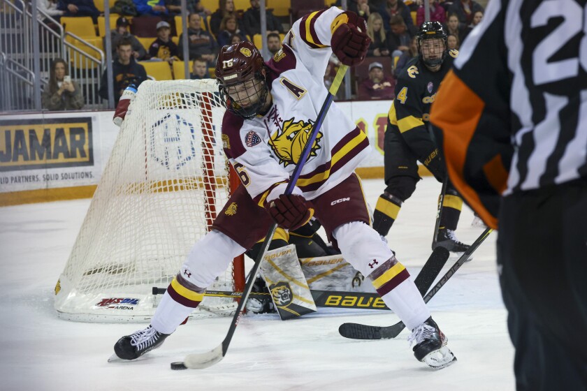 men's hockey players compete in game at indoor arena