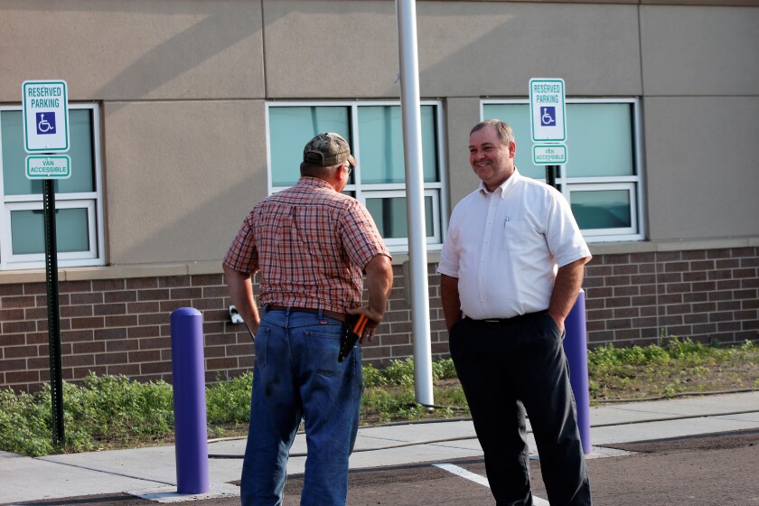 Superintendent of the White Lake School District Bob Schroeder talks with Jim Munsen, White Lake school board president, on Tuesday in front of the brand new school. (Sam Fosness / Republic)