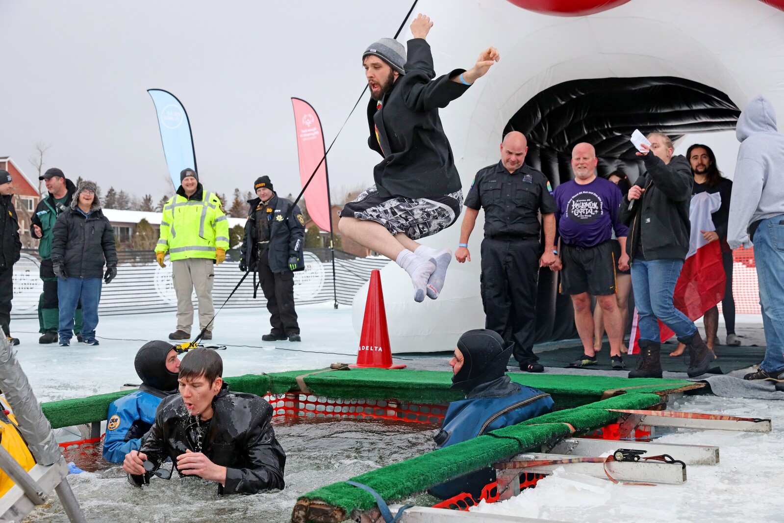 People jump into the water during the Polar Plunge event on Pelican Lake.