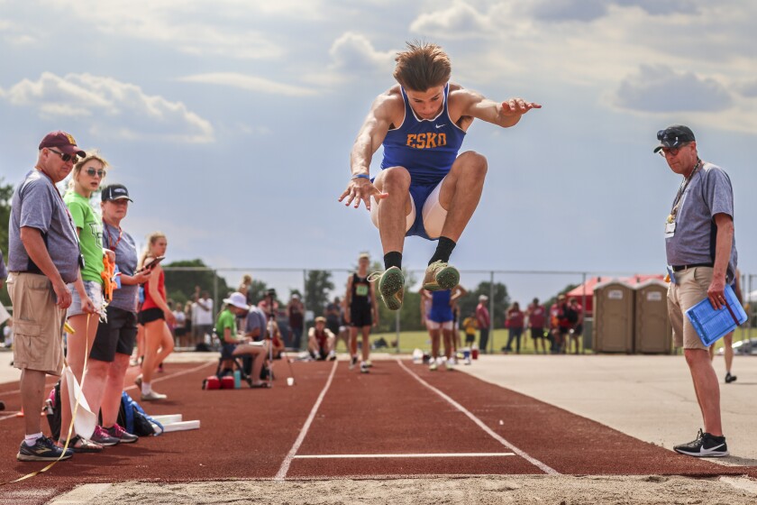 Athletes compete in track and field events at outdoor stadium