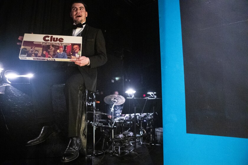 Mr. Boddy, played by Austin Willhite, holds up a physical copy of Clue during a dress rehearsal of "Clue: The Musical" at the Barn Theatre on Thursday, March 24, 2022.