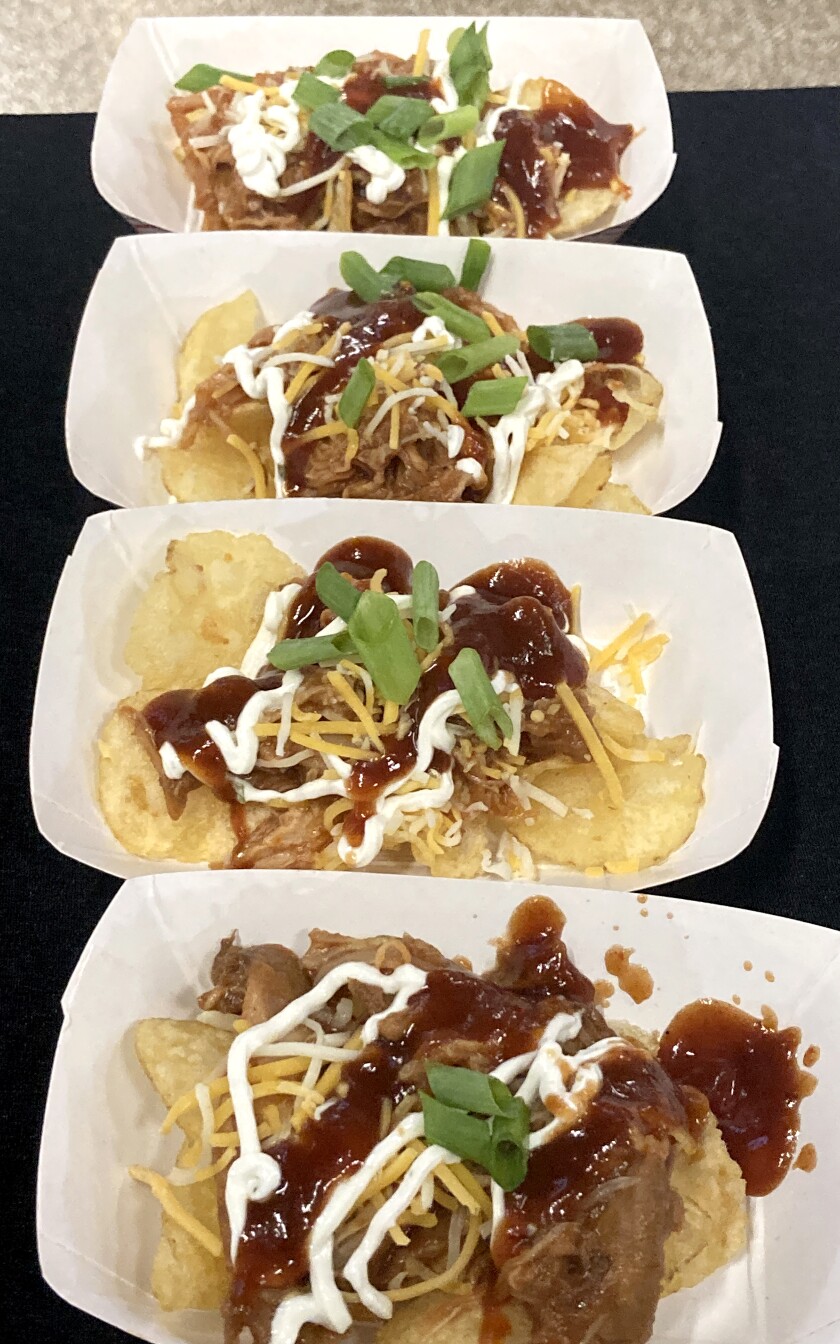 A row of paper trays containing barbecue chicken clipper.
