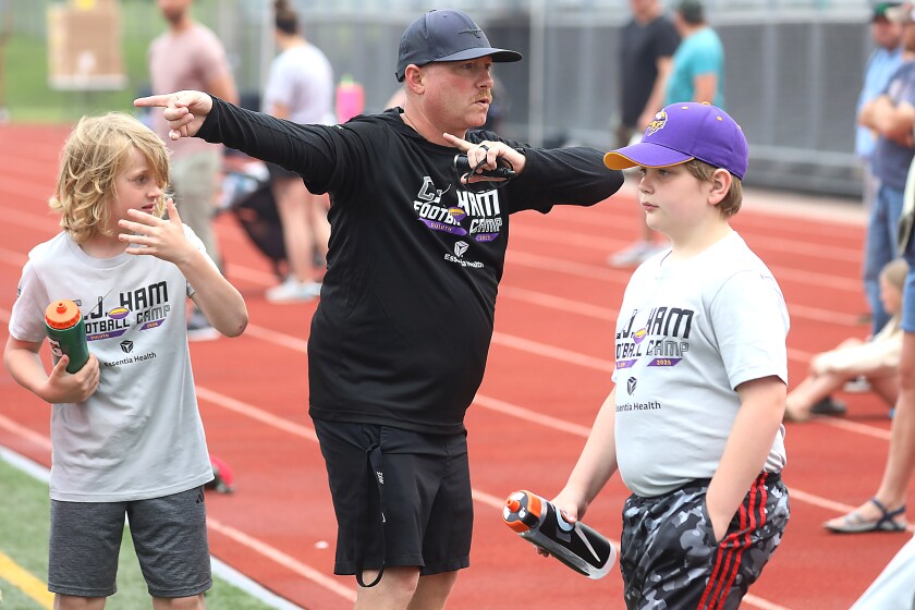 A football coaching pointing while giving instructions to youth players.