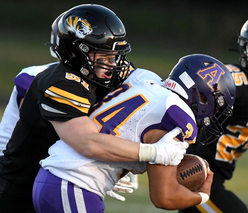 Northwestern’s Ian Smith (51) tackles Ashland’s Laken Villaverde (34) in the first quarter