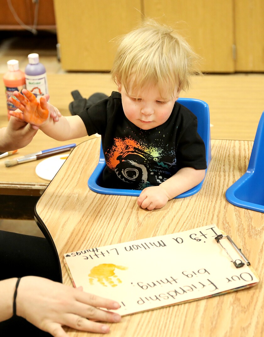 One-year-old Camden Holm looks at his hand print