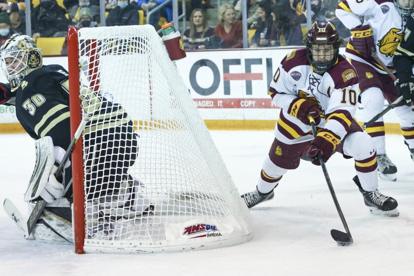 Men's hockey players in black uniforms compete against players in white uniforms at Amsoil Arena