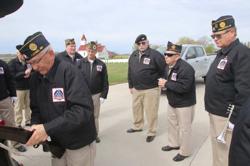 A small group of veterans organize their equipment for a funeral.