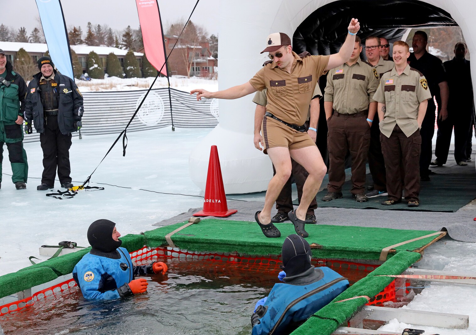 People jump into the water during the Polar Plunge event on Pelican Lake.