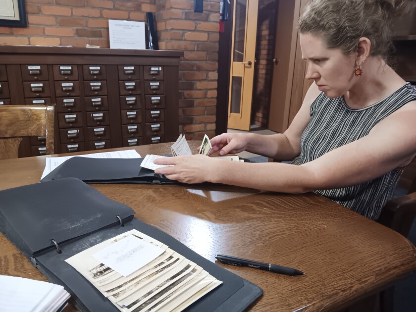 Hillary Swanson, administrátorka/výkonná ředitelka historické společnosti Crow Wing County Historical Society, se dívá na jedno z fotoalb, které objevili Jim a Susan Knudsen v úterý 22. července 2025.