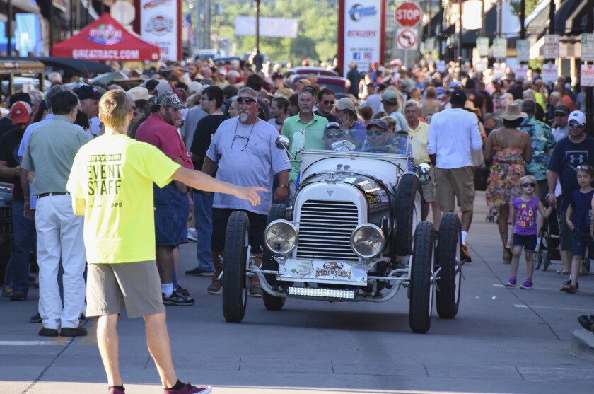 A classic car being parked during a race. 