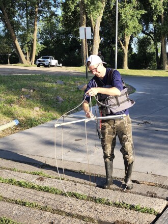 Charles Egberg, project assistant with Carp Solutions, assembles a piece of equipment called a spider, which will deliver electrical shocks to carp in order to stun them, so that they can be netted and chipped for tracking. Egberg and William Wright, fisheries specialist, also with Carp Solutions, will be electrofishing and installing box nets on Lake Okabena for carp removal efforts this week.