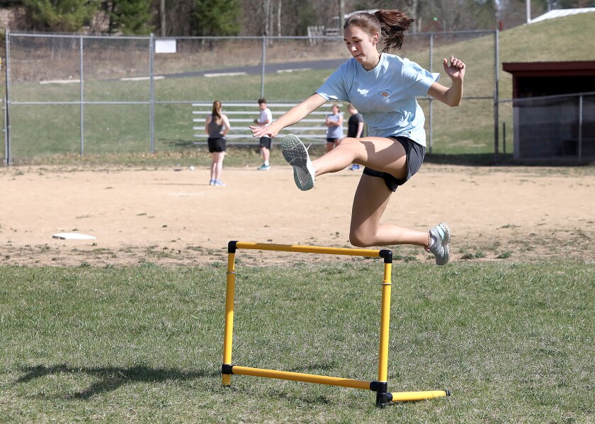 Northwood/Solon Springs hurdler Izzy Molina clears a hurdle in the grass of the outfield