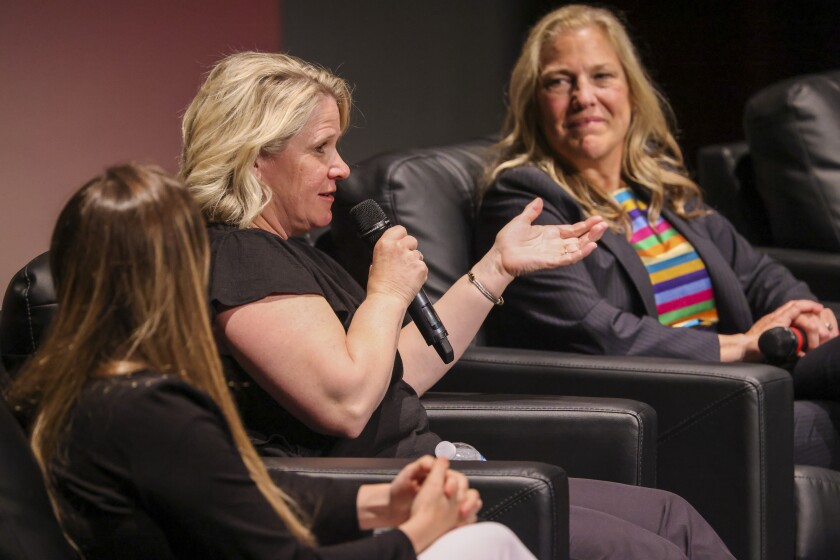 Women participating in live panel on theatre stage
