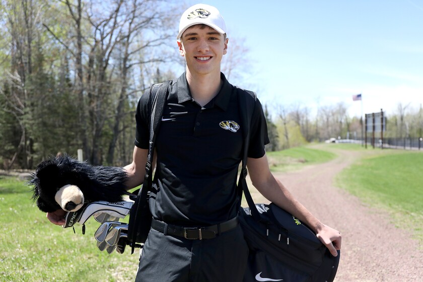 Trent Meyer holds his clubs outside of Northwestern High School