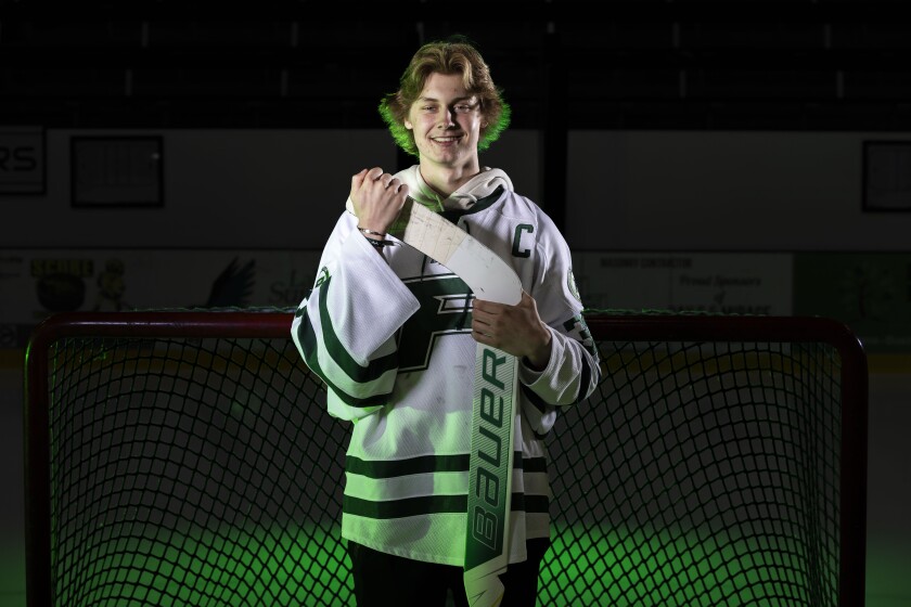 High school hockey player posing with his stick