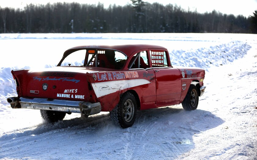 A 1957 Chevrolet car racing around a track