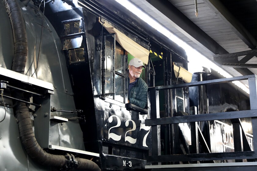 Rick McGarrey, of Buenos Aires, Argentina, leans out from a locomotive at the Lake Superior Railroad Museum