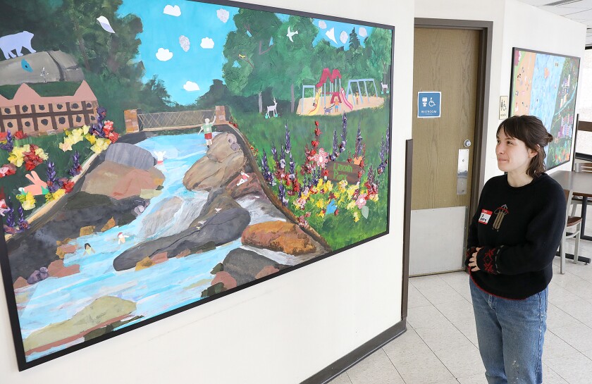 Liz Axberg, the Community Outreach Coordinator VISTA for the Duluth Art Institute, looks over one of the panels painted by Lincoln Park students