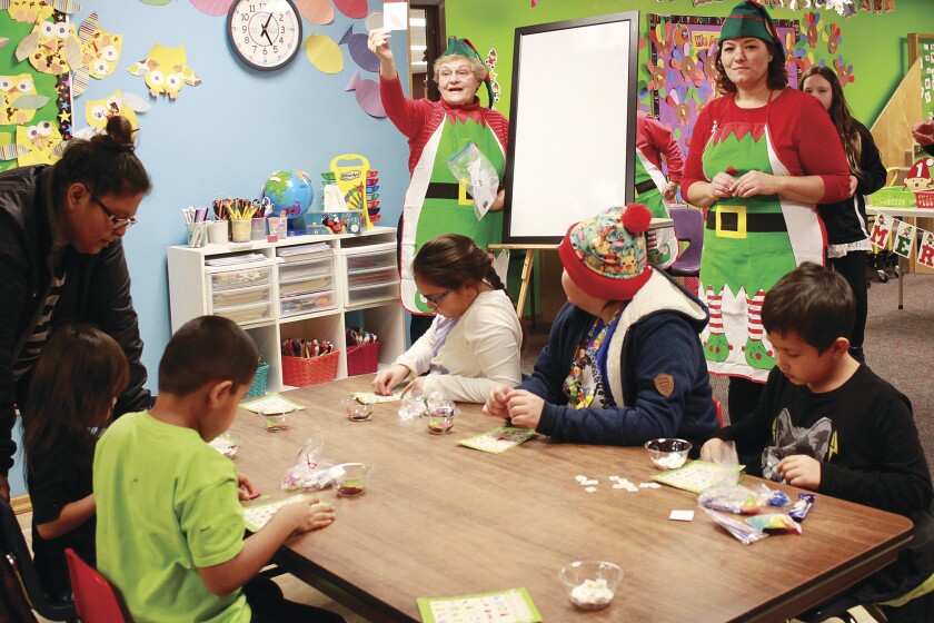 Judy Bilden holds up cards for Elf Bingo as daughter Ali Bilden Camps watches. The event, hosted by United Way of Carlton County, had 115 participants. Jamie Lund/Pine Journal