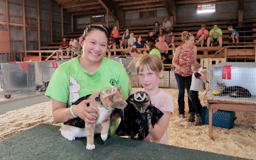 Mareah Carlson, of Windom, left, holds King Satsuki, and Abagail Nickel, of Mountain Lake, holds Queen Curls, after the cats were crowned as royalty at the Household Cat & Kitten Show on Wednesday, Aug. 10, 2022, during the Cottonwood County Fair.