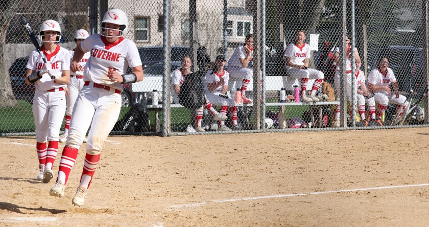 Luverne Cardinals Billi Connell jumps onto home plate as the dugout cheers the run during a Monday afternoon Game against the Worthington Trojans.