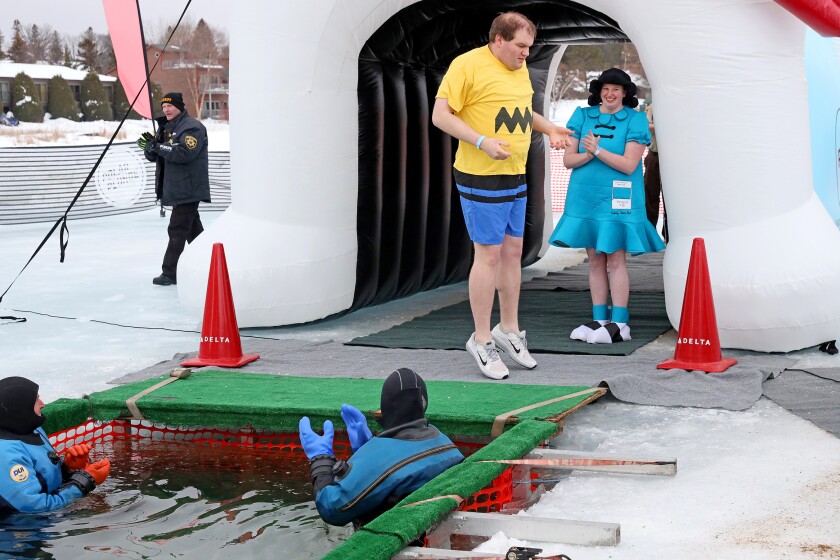 People jump into the water during the Polar Plunge event on Pelican Lake.