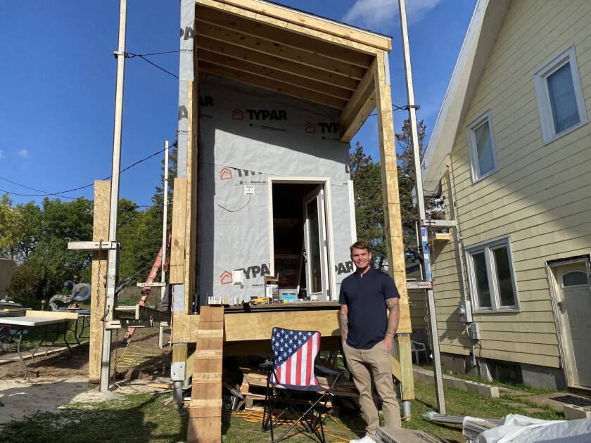 7b7e5f-20221205-a-man-stands-next-to-a-tiny-house-2000.jpg