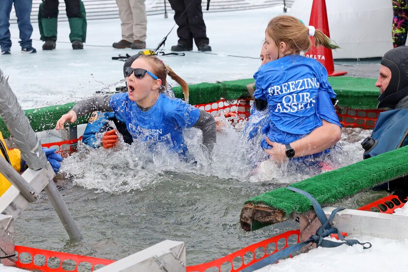 People jump into the water during the Polar Plunge event on Pelican Lake.