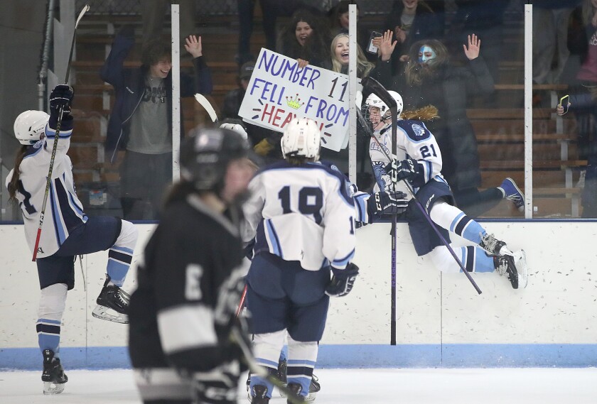 Superior’s Autumn Cooper (21) jumps into the boards as she celebrates Isabella Thompson’s game-winning goal in overtime