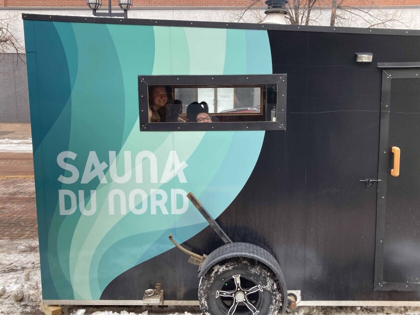 People looking through a window while sitting inside of a sauna