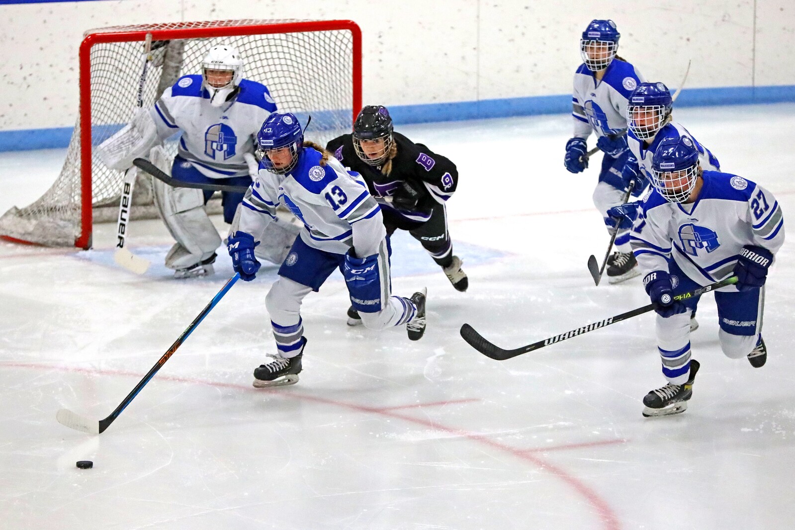 Players go after the puck.