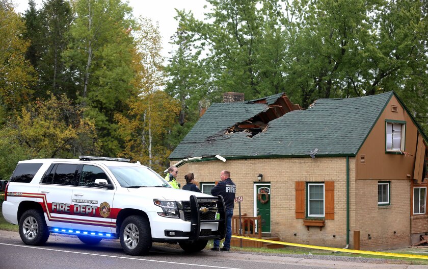 Emergency responders in front of a damaged home after a plane crash