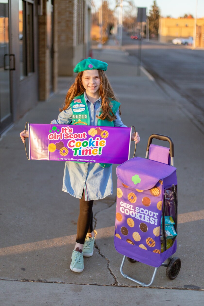 Ellisyn Ahmann, a Dickinson Girl Scout, holds her banner in her beret.