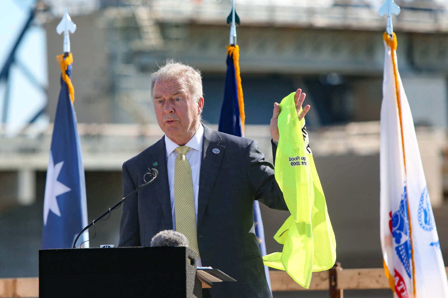 Fargo mayor Tim Mahoney speaks during a ceremony marking the rerouting of the Red River of the North through the Red River Control Structure on Aug. 7, 2025. Mayor Mahoney took off his bright yellow vest that he is known to wear during flood fights and said that he won't be needing it anymore.