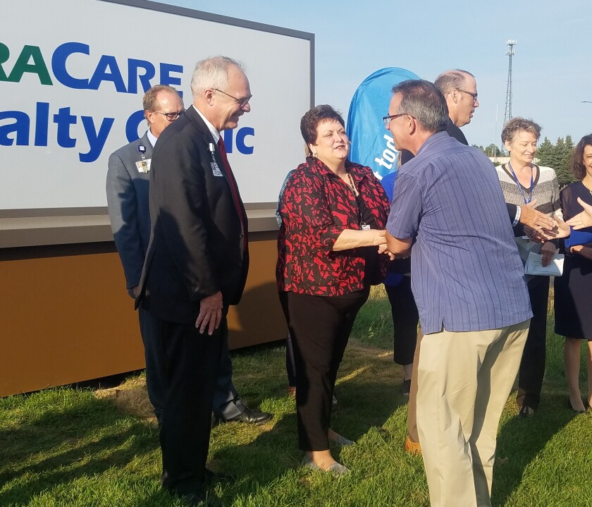 Brian Lehman, of the Brainerd Lakes Chamber of Commerce, shakes hands with CentraCare staffers Mark Thompson and Kimberly Murray Monday, Sept. 17, after a ribbon-cutting ceremony at the new facility in Baxter. Theresa Bourke / Brainerd Dispatch