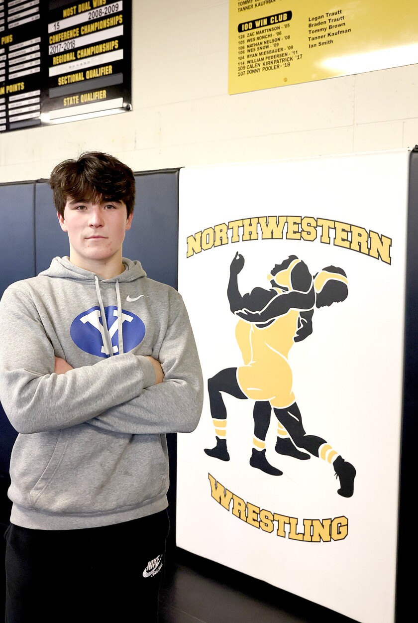 Wrestler stands by 100 win board.