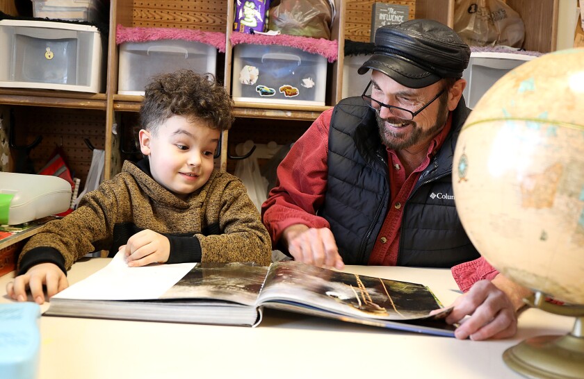 Clayton Heikkila, 7, left, and David Deeth look at a book about bees