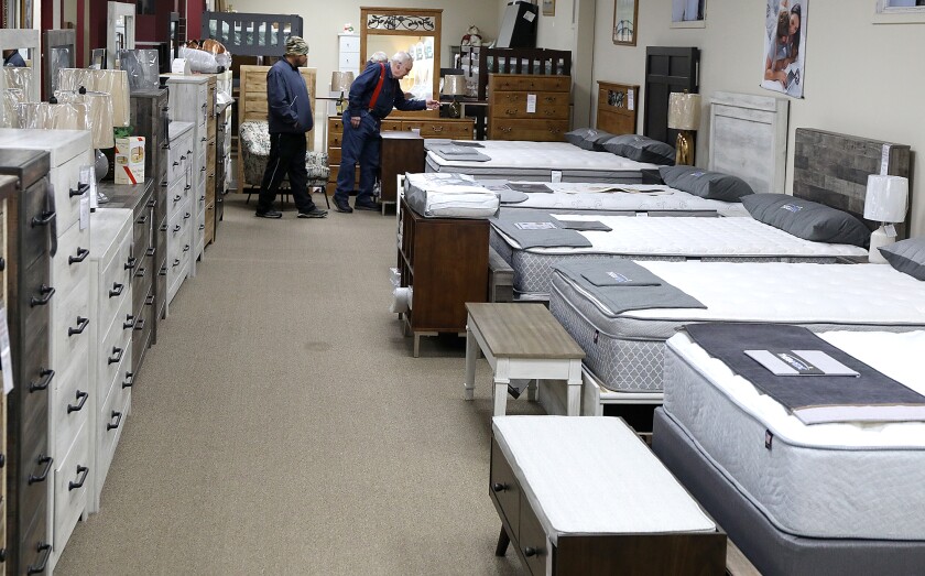 Dave Cochran, right, owner of Dave’s Cloquet Mattress & Furniture, helps a customer looking for a bed in the store